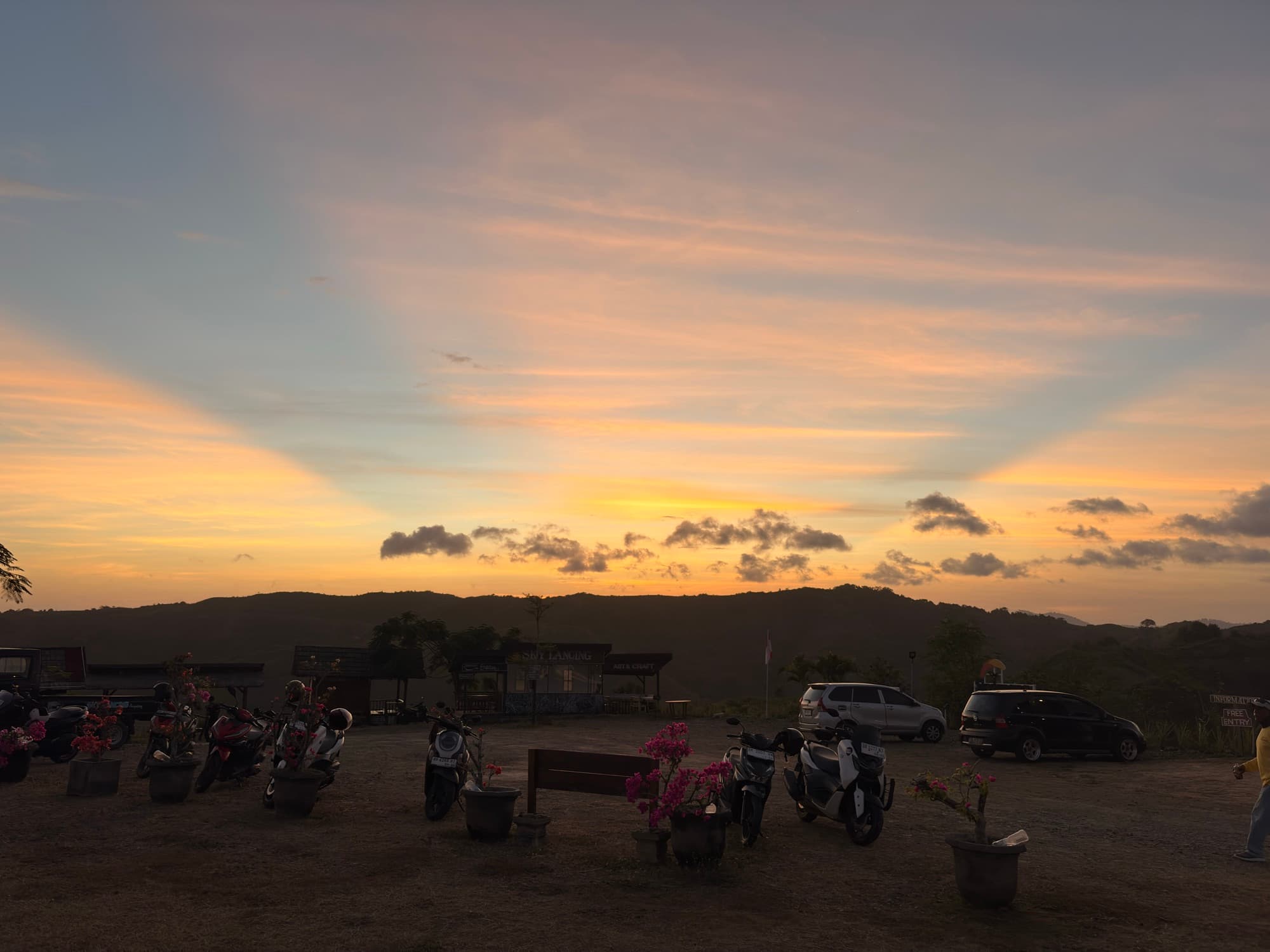 Sonnenuntergang an einem Aussichtspunkt, Roller und Leute im Vordergrund