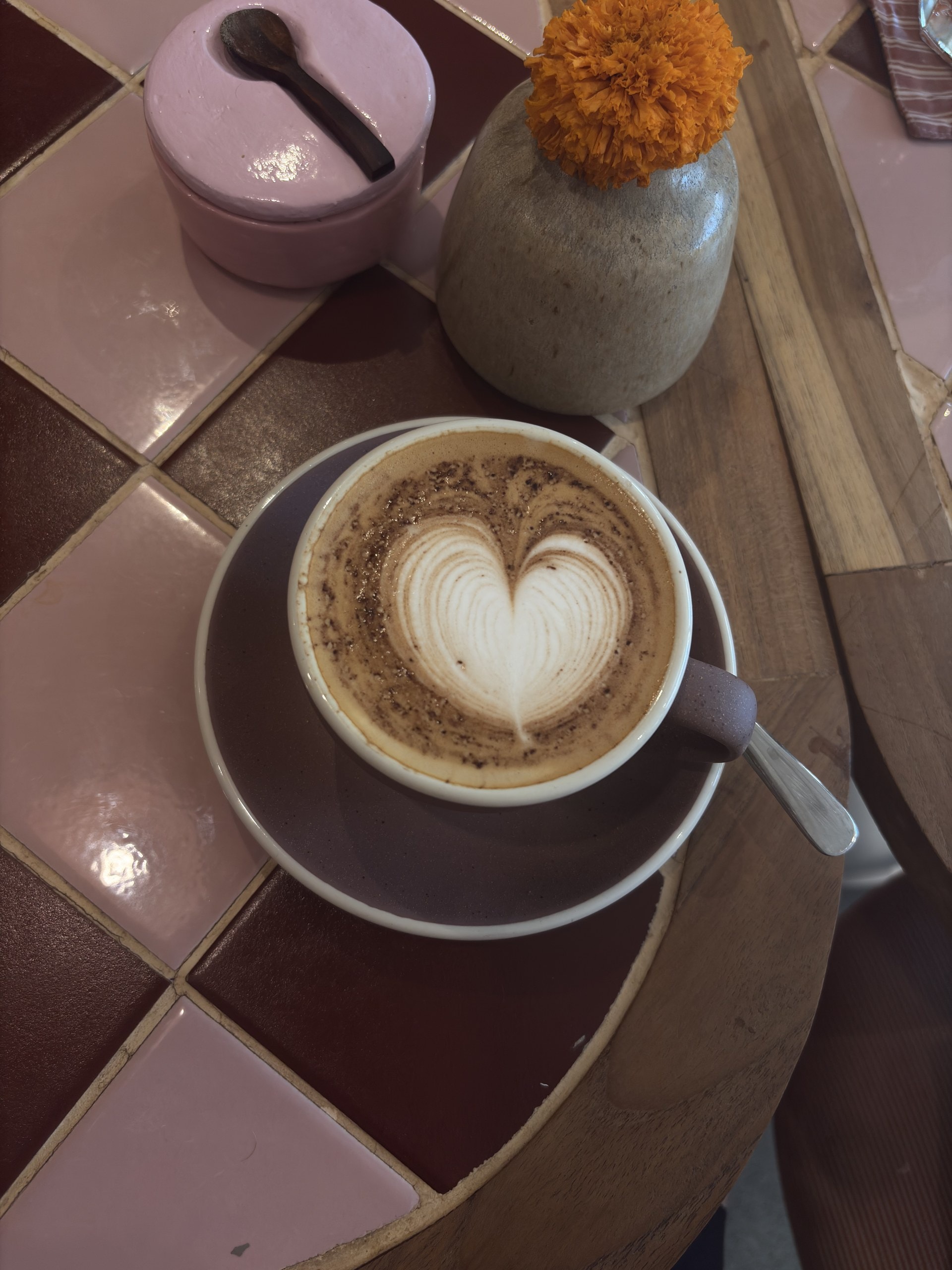 Cappuccino mit einem Herz im Milchschaum auf einem gefliesten Tisch