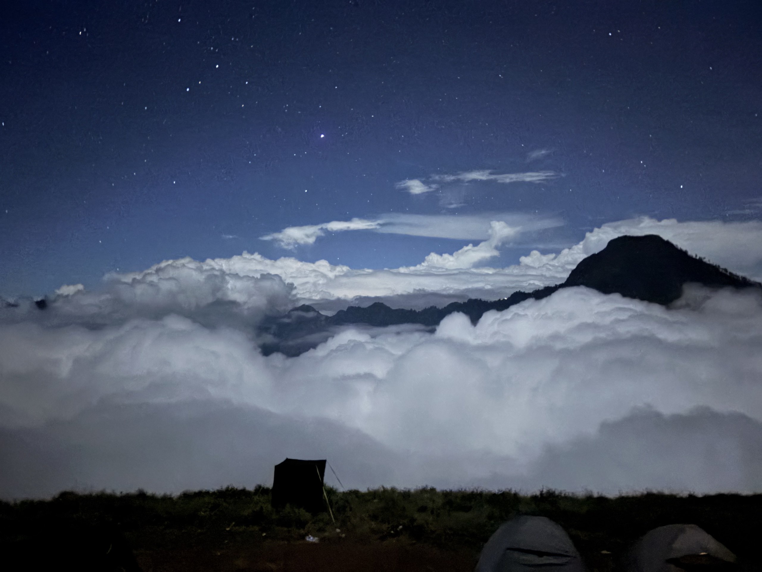 Wolkenmeer unter dem Zeltlager, darüber der Sternenhimmel